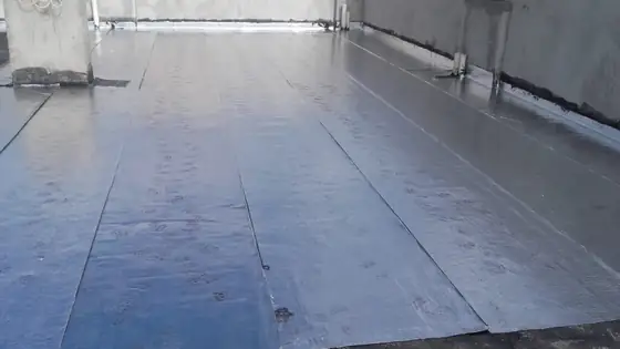 Laje coberta de manta aluminizada em faixas sobrepostas, com a manta subindo nas paredes laterais